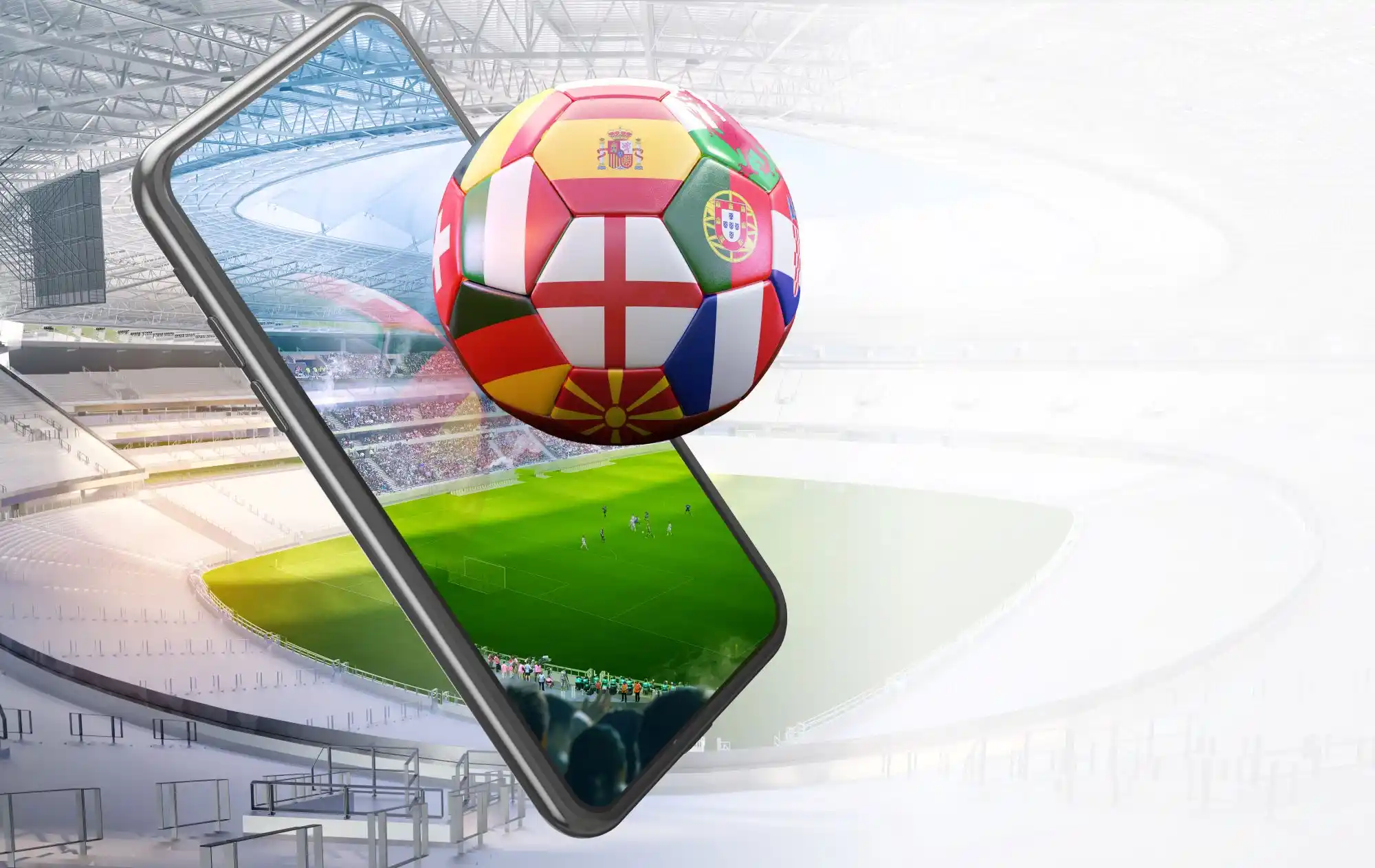 Smartphone und Fussball mit europaeischen Flaggen vor einem Fussballstadion.