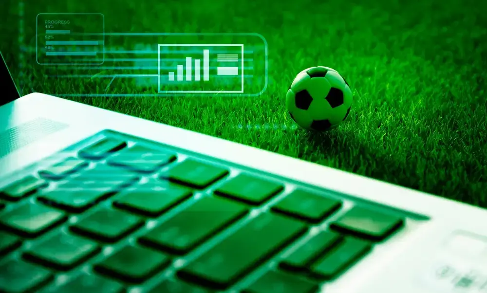 Fußball und Laptop und Animation einer Statistik auf Rasen